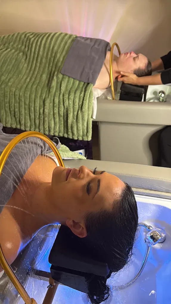 Two guests receiving head spa treatments side by side — group bookings from Bothell run 5 to 10 guests