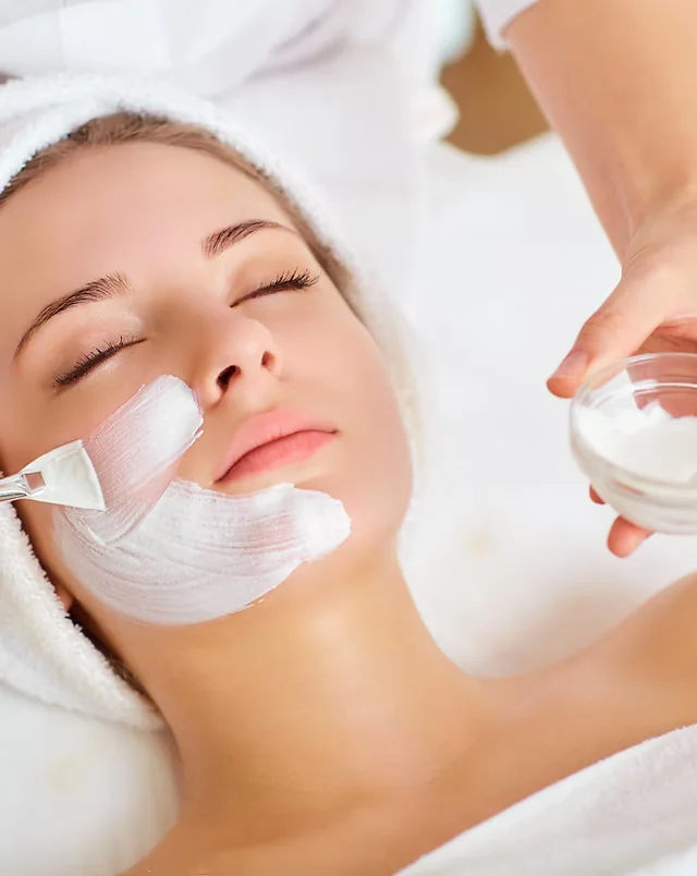 Facial mask being brushed onto a guest's cheeks during a Comfort Zone facial