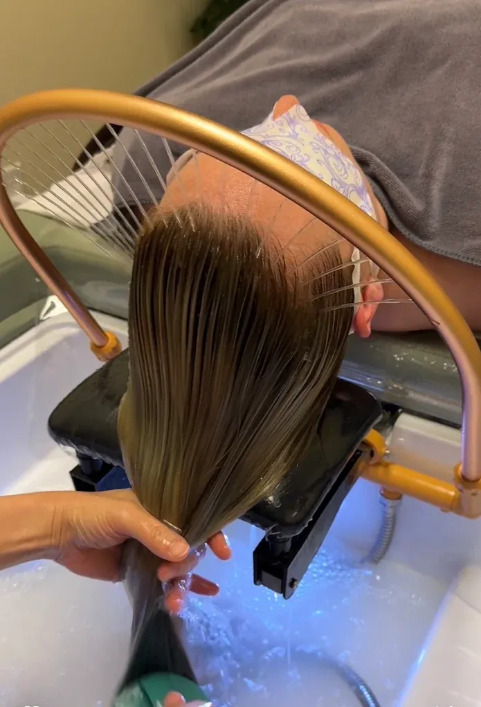 Therapist rinsing a client's hair at a Soul Massage Head Spa station