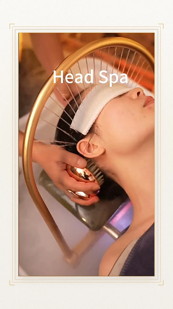 Therapist working a scalp brush under the gold water arch during a head spa at Soul Massage Head Spa